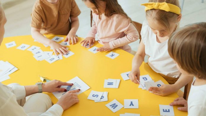 A lady is teaching the alphabet to kids