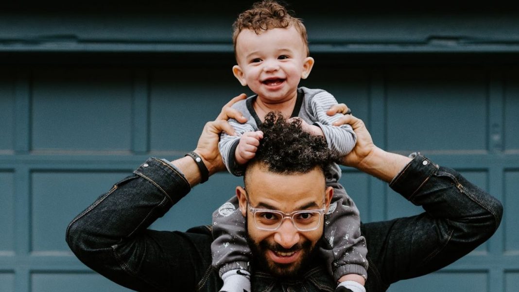 Kid sitting on his dad’s shoulders