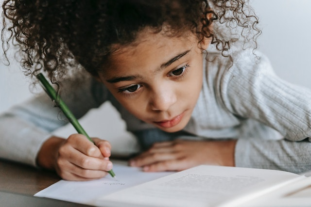 Child focusing on journaling assignment