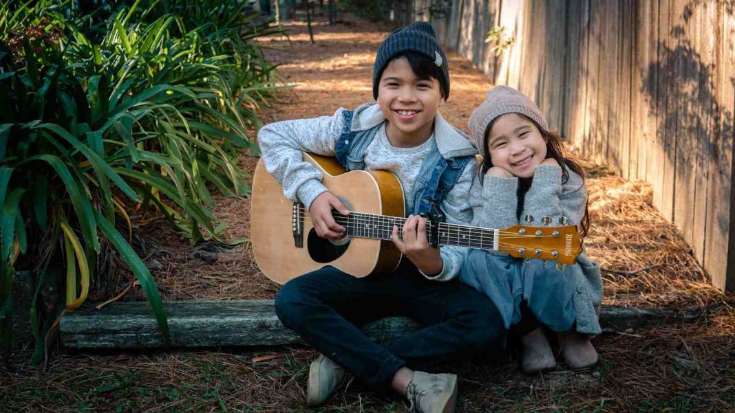 Kids sitting and playing guitar