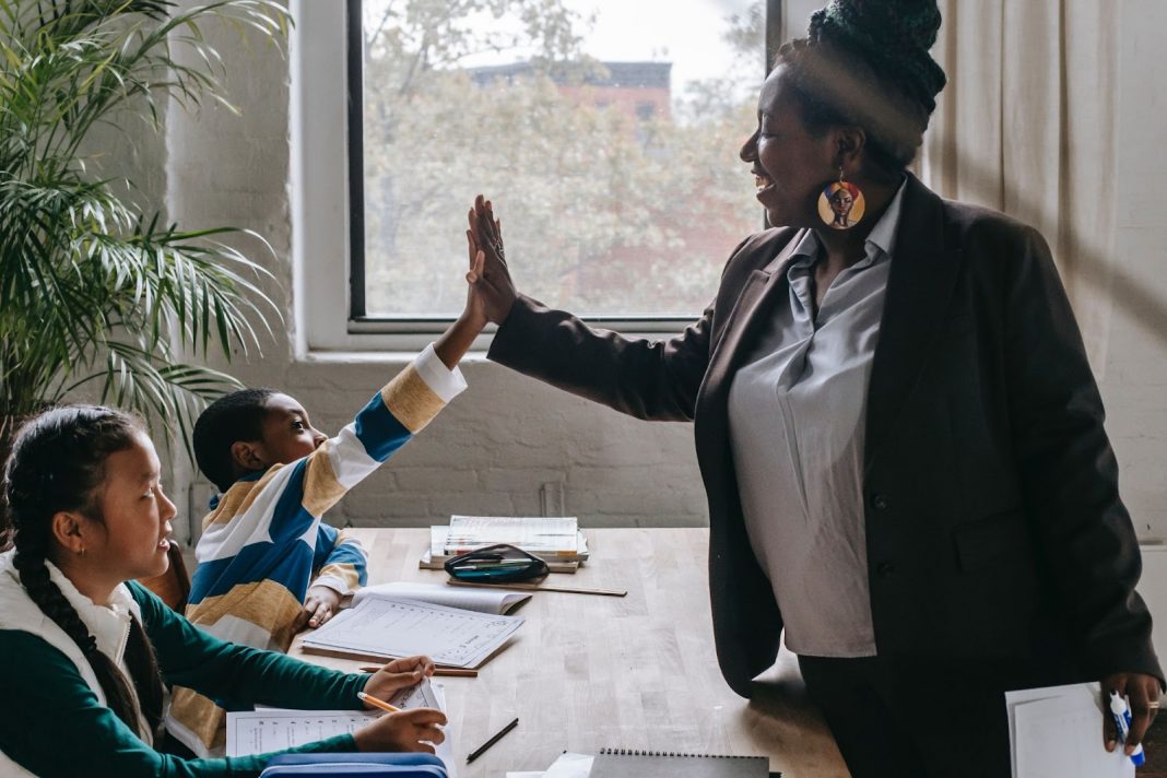 Teacher happily giving high five to student