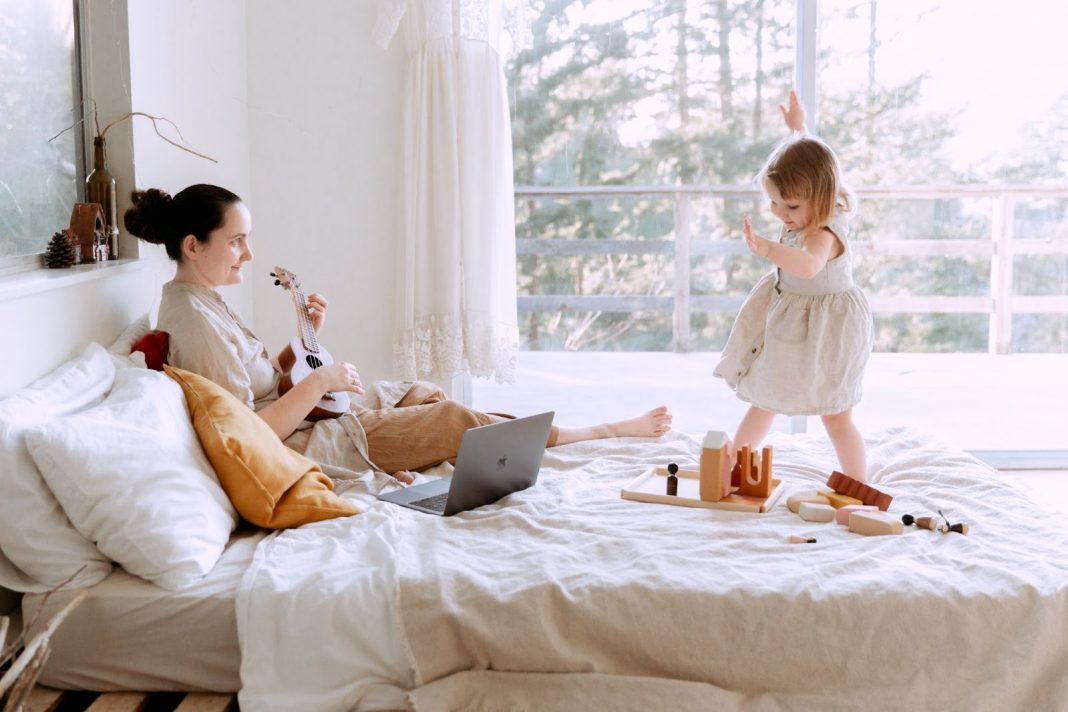 Happy woman playing ukulele for daughter