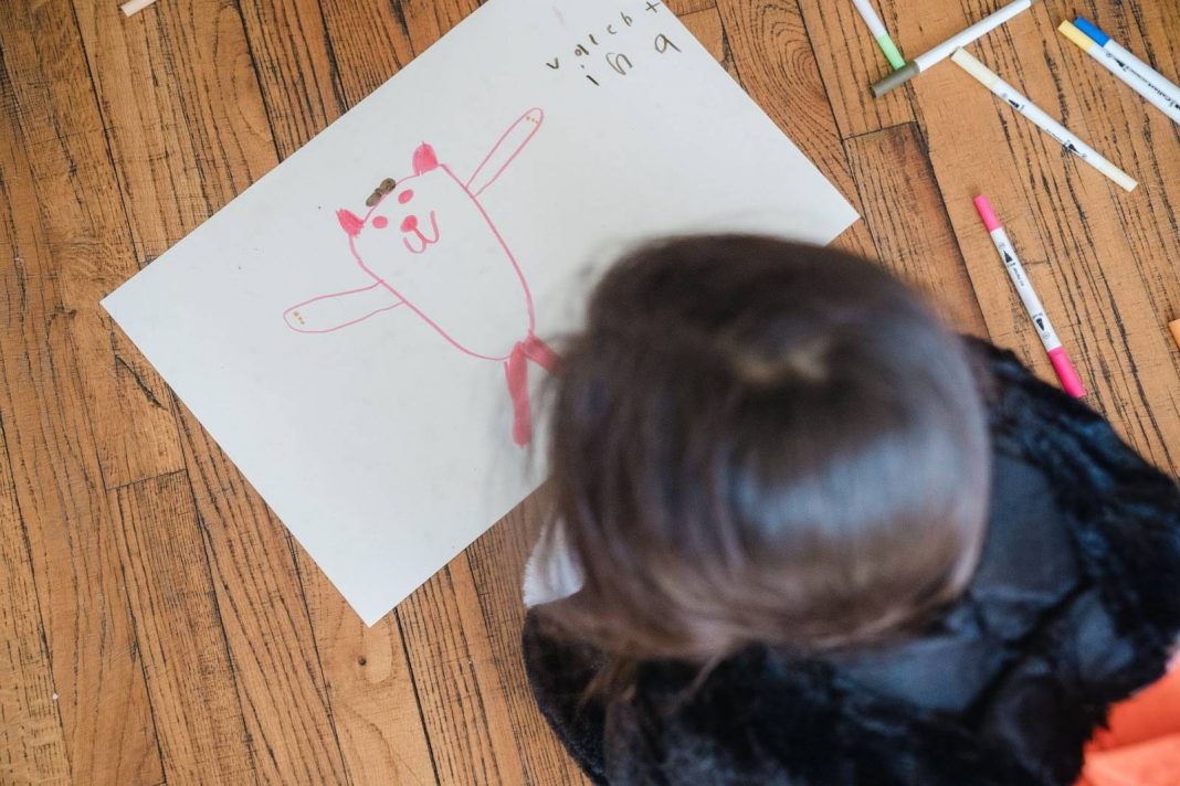 Little Girl Lying on the Floor and Drawing