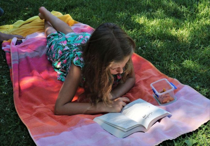 Girl reading a book in a garden