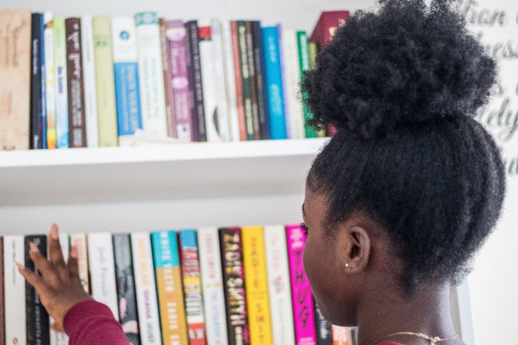 Girl choosing a book from a book shelf