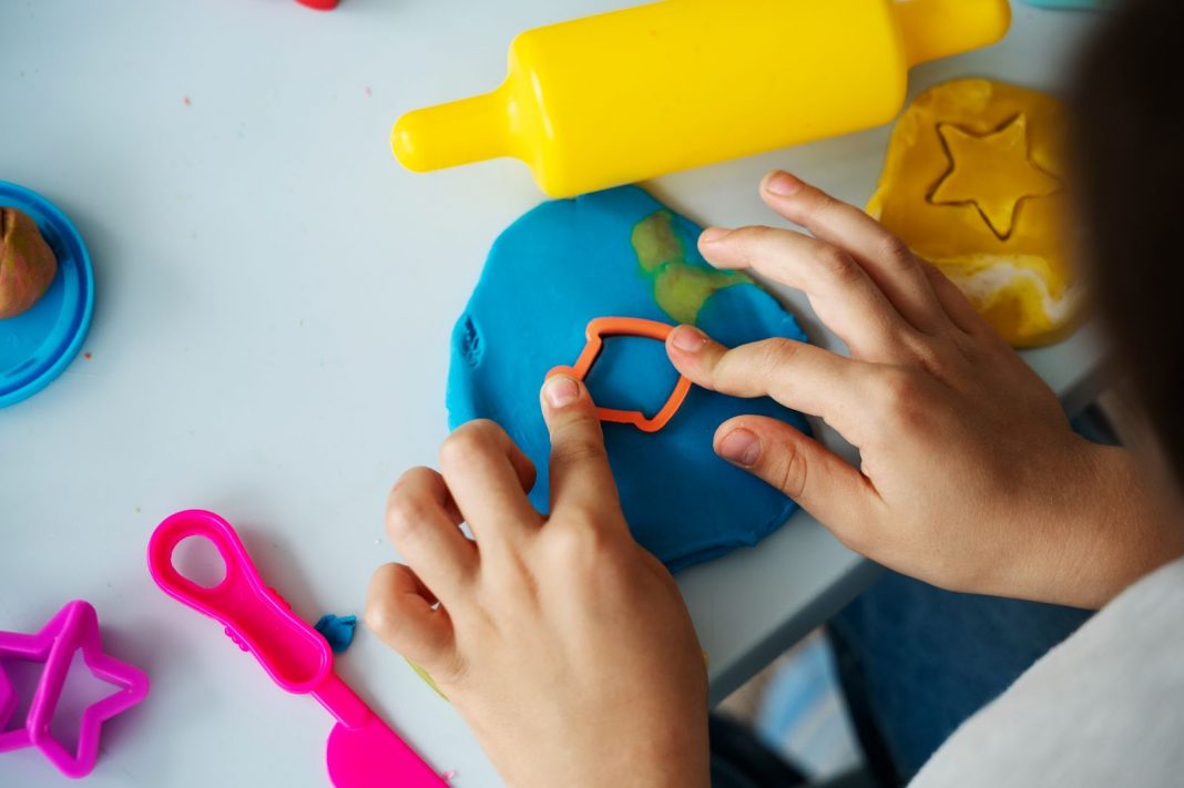 Kid using playdough for craft