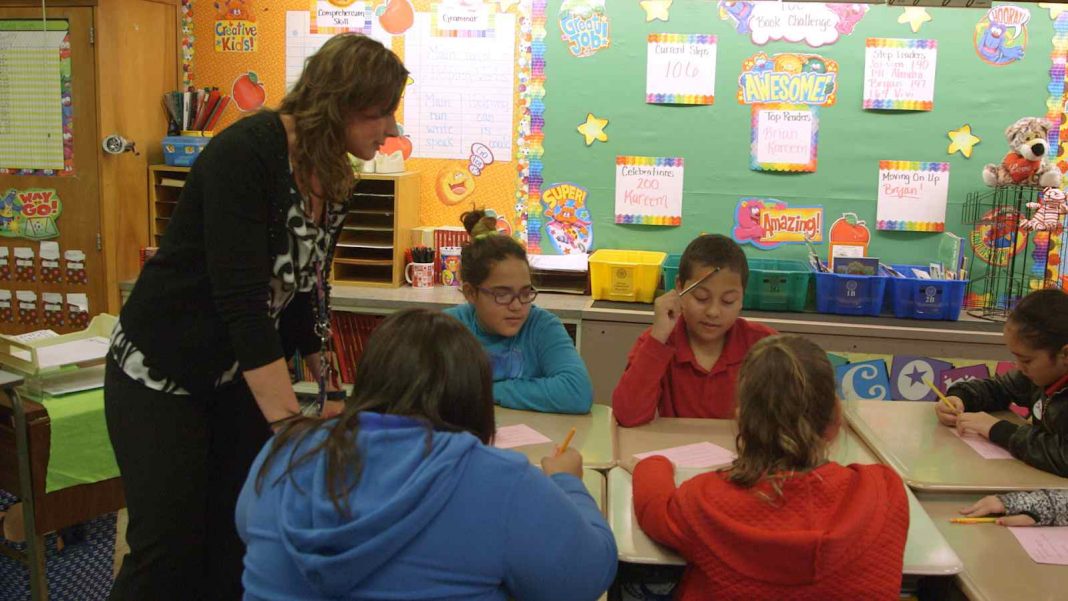 A teacher teaching 5th graders