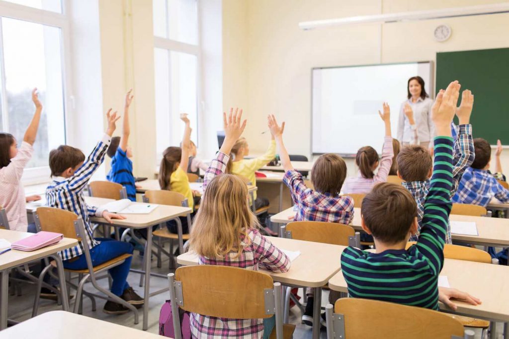 Kids raising hand in the class