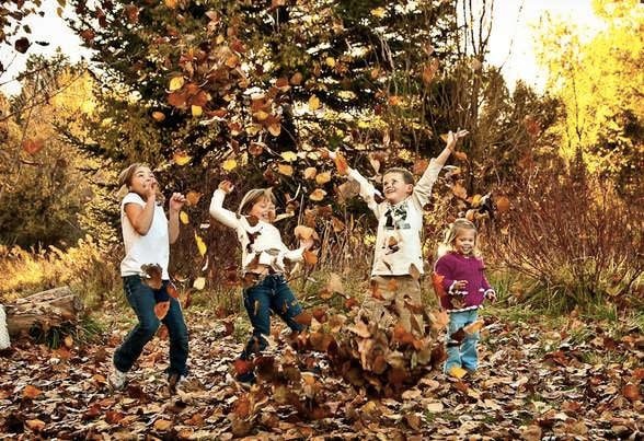 Kids playing with fall leaves