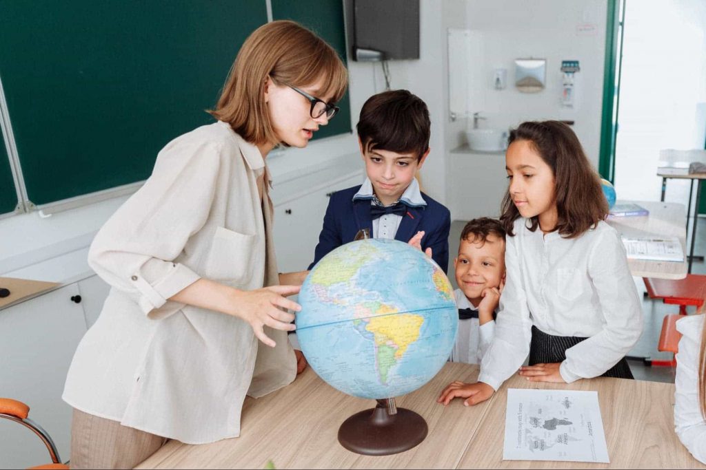 An image of a teacher teaching a group of 2 students