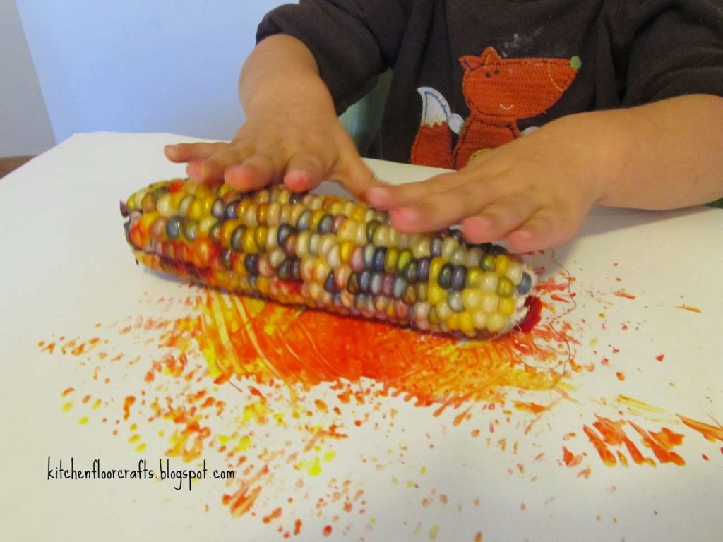 Kid rolling corn on paper