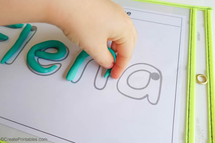 Kid using playdough to write name