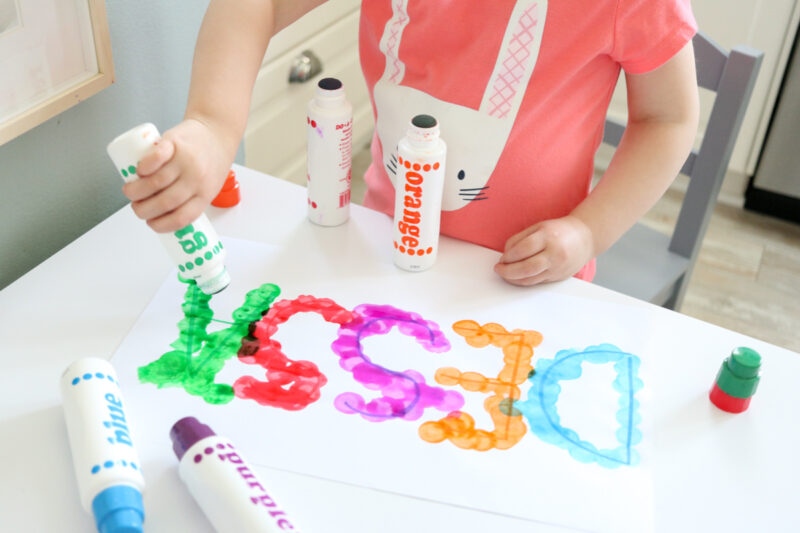 Kid putting dots on letters