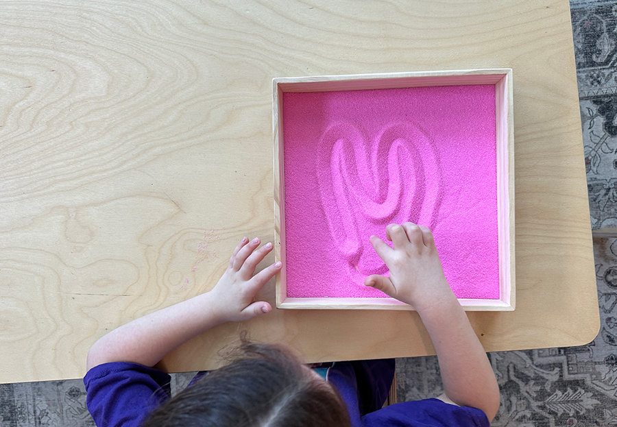 Child tracing on sand