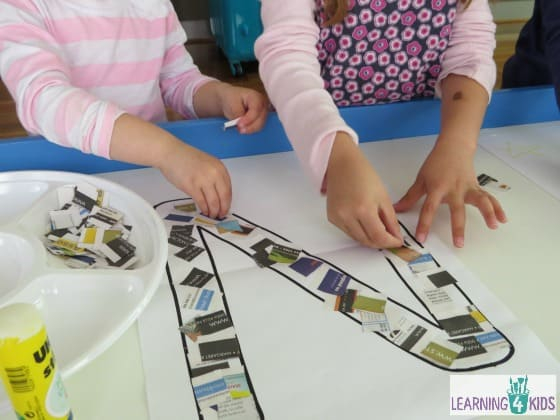 Two kids making a letter N collage