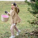 Small girl running with fruit in hand